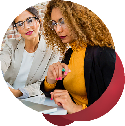 two female executives work together on a laptop