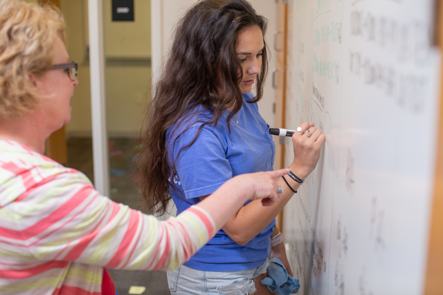 Psychology student and professor work together at a whiteboard
