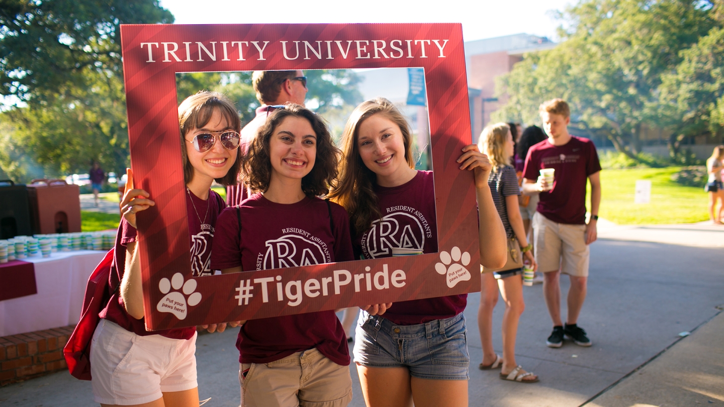 Students taking photo with giant photo frame that says Trinity University TigerPride