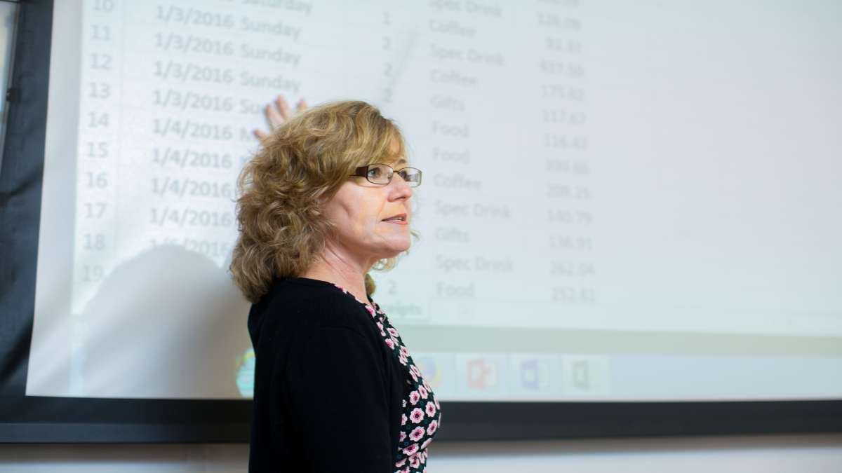 Professor standing in front of PowerPoint display