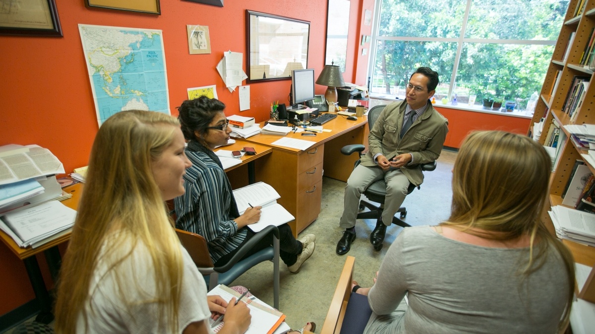 Students gathered around Professor participating in a groupdiscussion