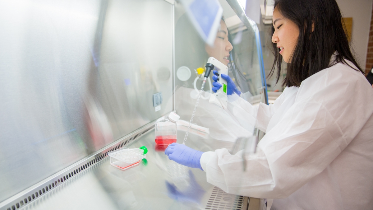 Student mixing fluids in a lab