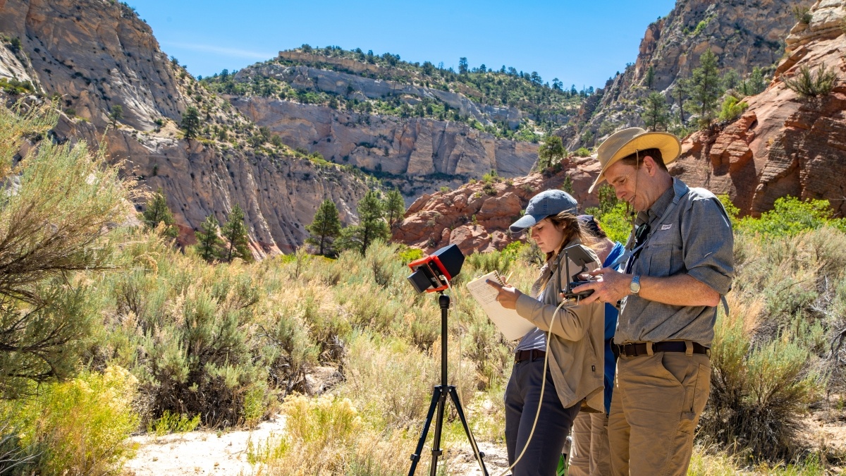 Professor and students taking measurements in canyon