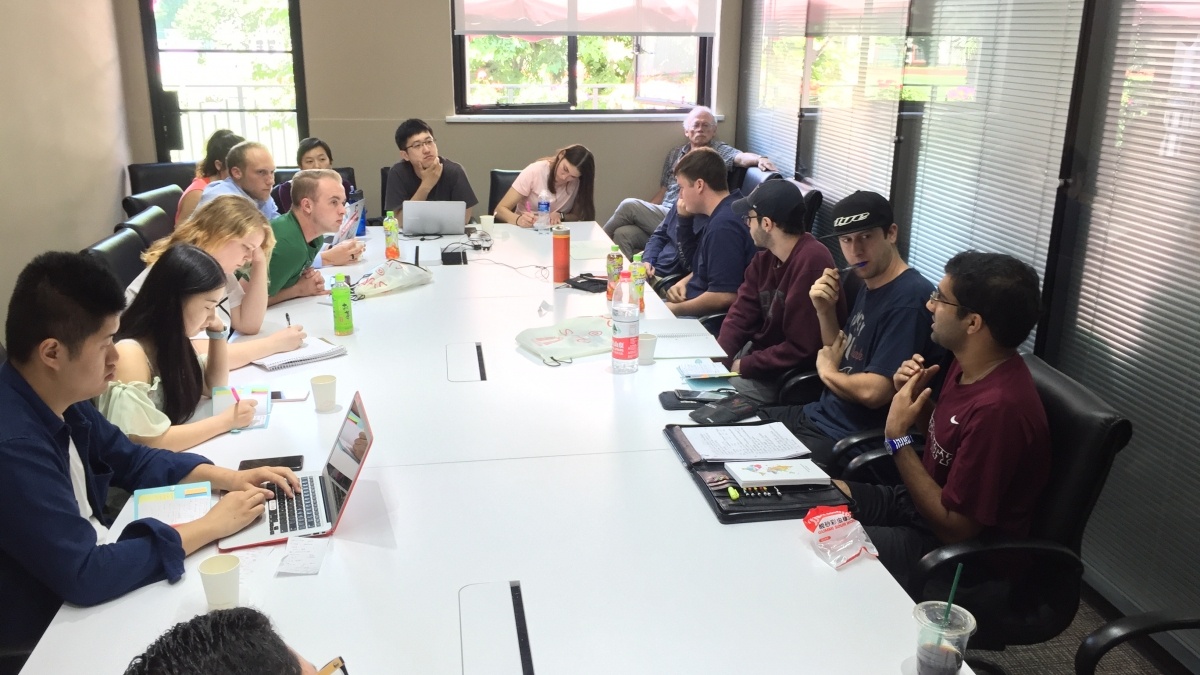 Group of people sitting at long board table