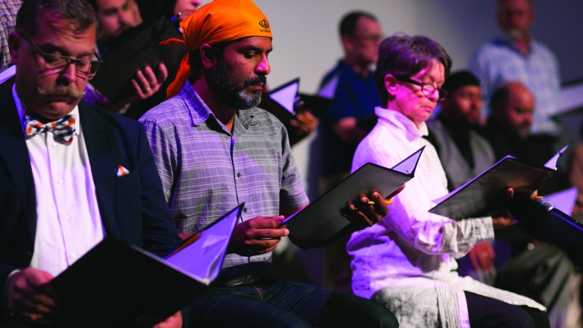 a group of ethnically diverse people holding folders from which to read