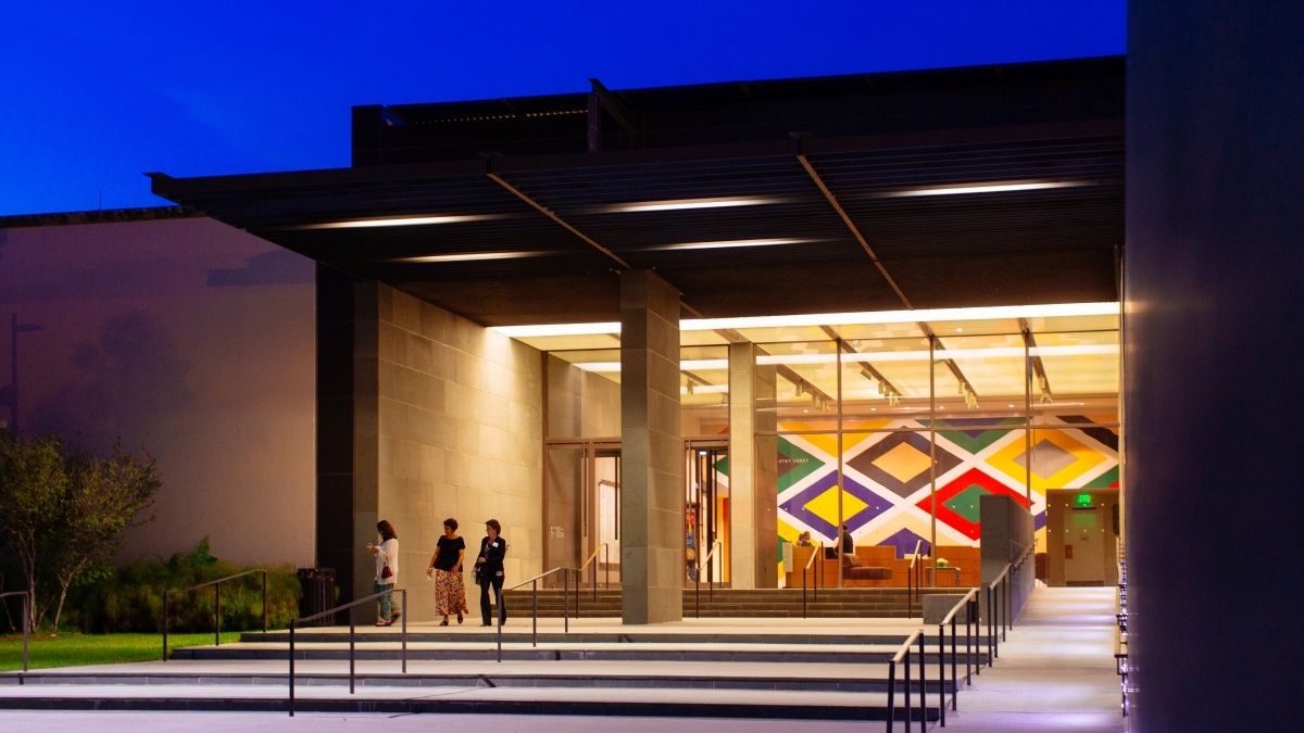 Three students at the entrance of a museum.